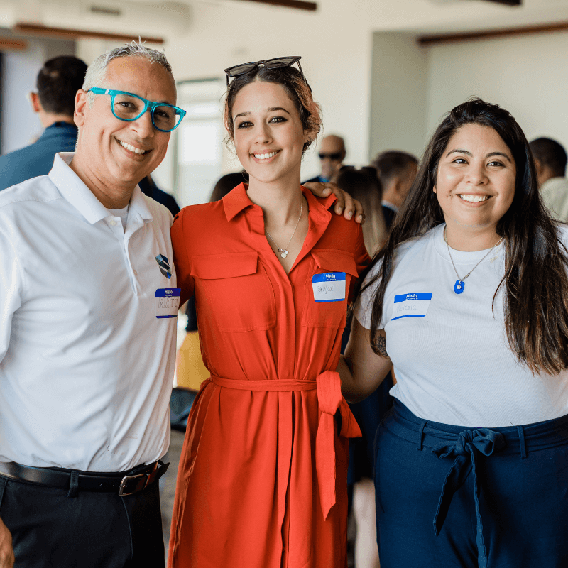 3 Significance colleagues, smiling with their arms around each others shoulders